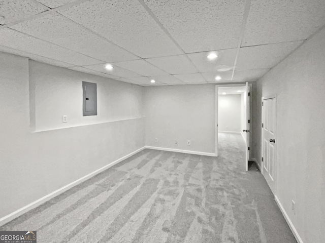 finished basement featuring carpet floors, recessed lighting, a drop ceiling, electric panel, and baseboards