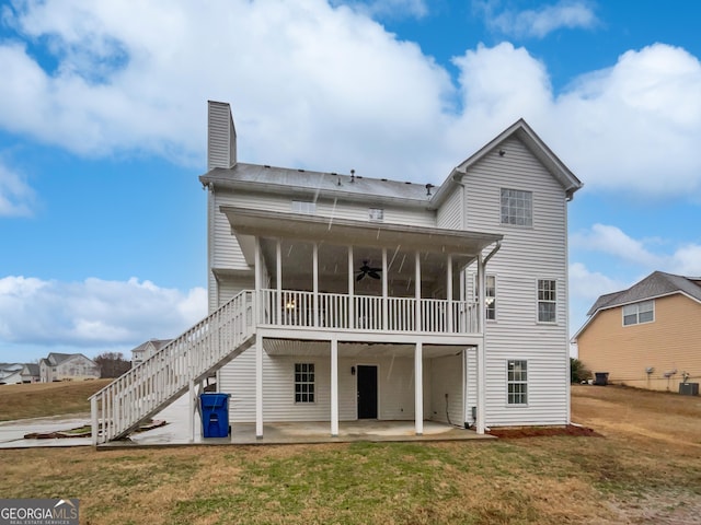 back of house with a patio, a lawn, a sunroom, ceiling fan, and stairs