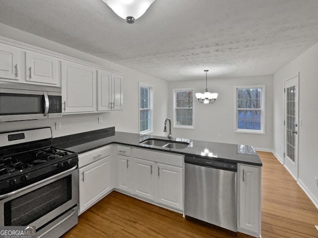 kitchen featuring stainless steel appliances, dark countertops, and white cabinetry