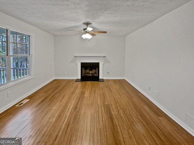 unfurnished living room featuring light wood-type flooring, baseboards, a fireplace, and visible vents