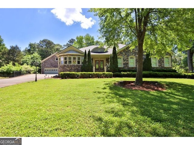 single story home featuring a garage, driveway, and a front yard