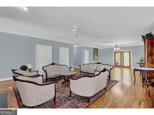 living room with light wood finished floors, french doors, ornamental molding, and baseboards