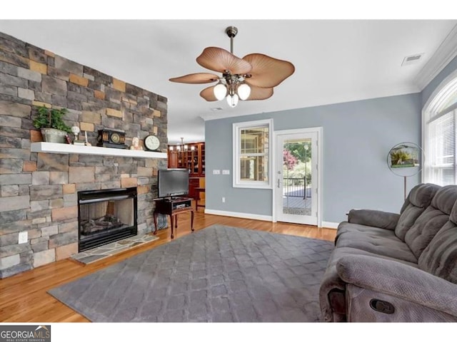 living area with a fireplace, visible vents, and wood finished floors