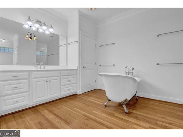 bathroom featuring baseboards, ornamental molding, a freestanding bath, and wood finished floors