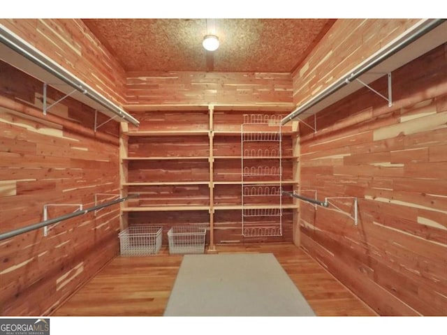 walk in closet with wood finished floors