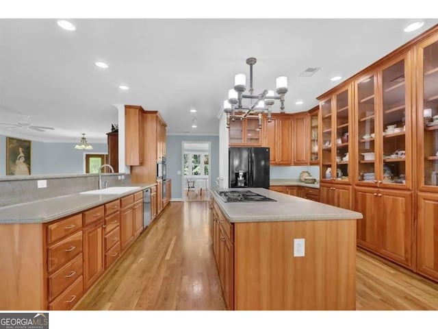 kitchen featuring light countertops, appliances with stainless steel finishes, glass insert cabinets, and pendant lighting