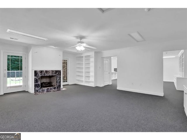 unfurnished living room with dark colored carpet, a fireplace, visible vents, and a ceiling fan