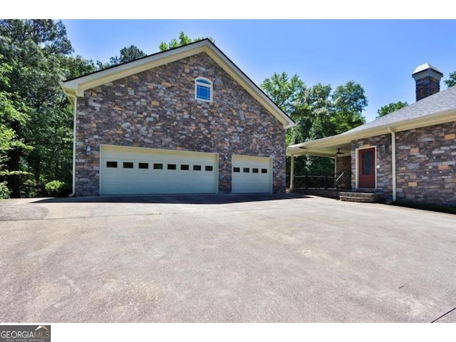 view of home's exterior with driveway and a chimney