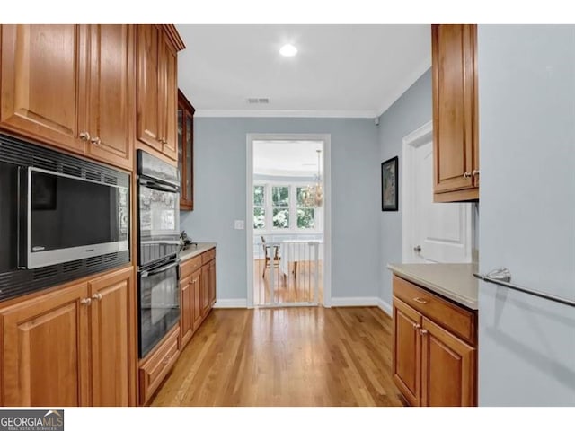 kitchen with ornamental molding, brown cabinetry, dobule oven black, and built in microwave