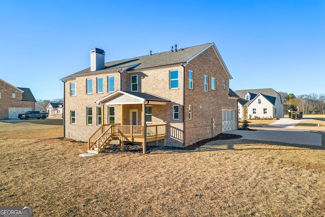 1295 Stonewood Field Rd, Watkinsville, GA 30677 - rear view of property with a chimney, an attached garage, brick siding, driveway, and a lawn