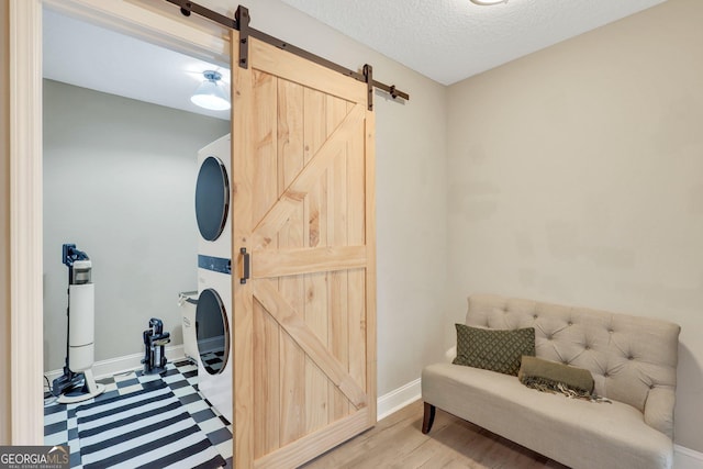 interior space featuring a textured ceiling, a barn door, and baseboards