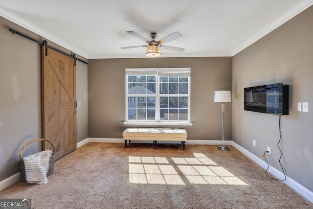 unfurnished room featuring carpet floors, crown molding, and a barn door