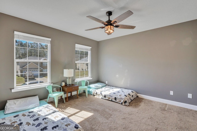 bedroom with carpet floors, multiple windows, baseboards, and a ceiling fan