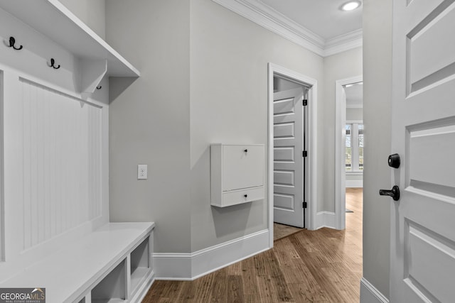 mudroom with ornamental molding, baseboards, and wood finished floors