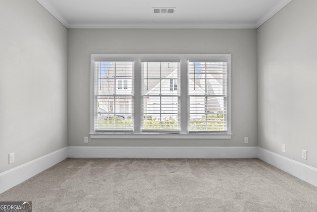 carpeted empty room with baseboards, crown molding, visible vents, and a wealth of natural light