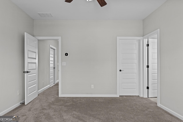 unfurnished bedroom with carpet floors, visible vents, baseboards, and a ceiling fan