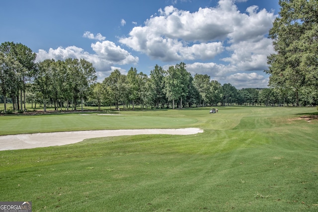 surrounding community featuring view of golf course and a yard