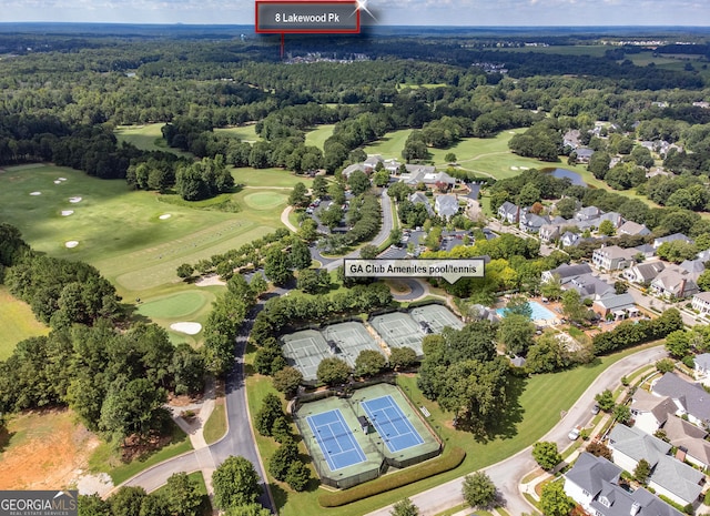 aerial view with view of golf course and a wooded view