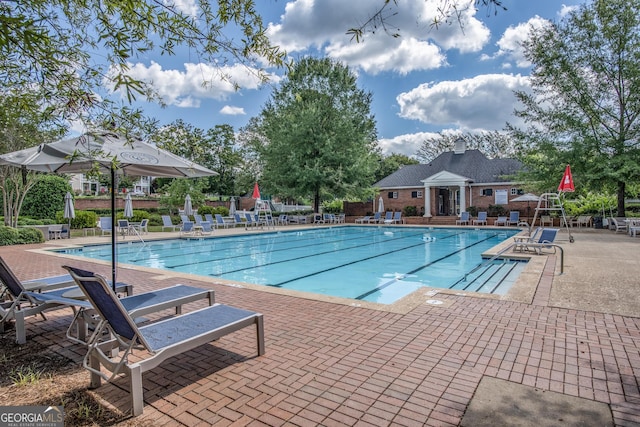 community pool with a patio area and fence