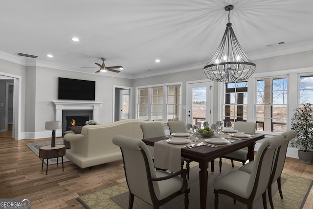 dining space with plenty of natural light, wood finished floors, and crown molding