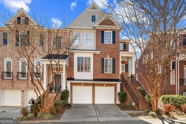 view of property featuring an attached garage, stairway, concrete driveway, and brick siding