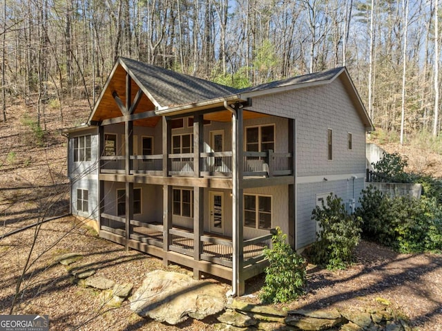 exterior space featuring a shingled roof and a balcony