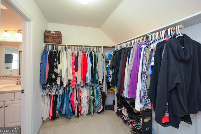 walk in closet featuring lofted ceiling and a sink