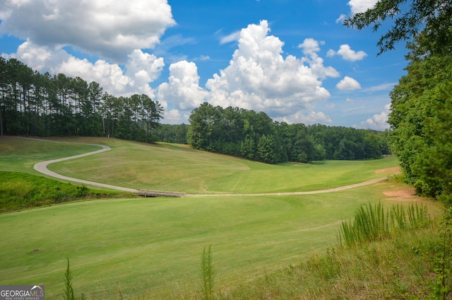 surrounding community featuring view of golf course and a yard