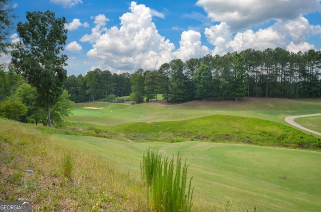 view of home's community with view of golf course and a lawn