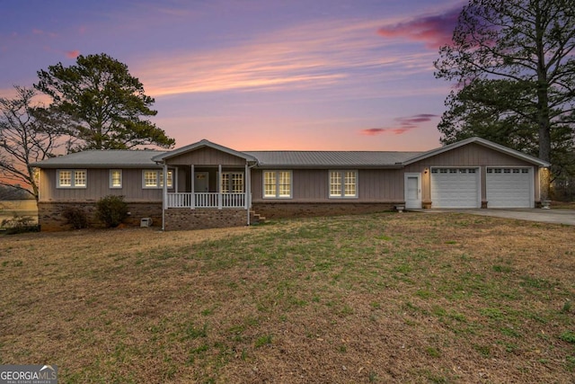 single story home with a porch, an attached garage, and a front yard