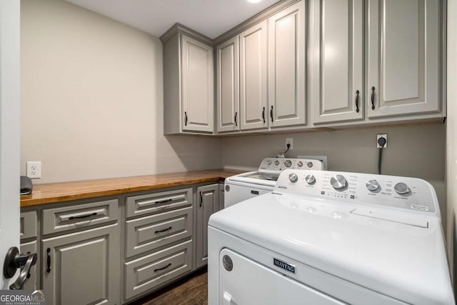 laundry area with cabinet space, dark wood-style floors, and washer and dryer