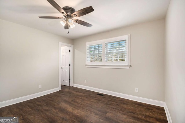 unfurnished room with dark wood-style floors, visible vents, baseboards, and a ceiling fan