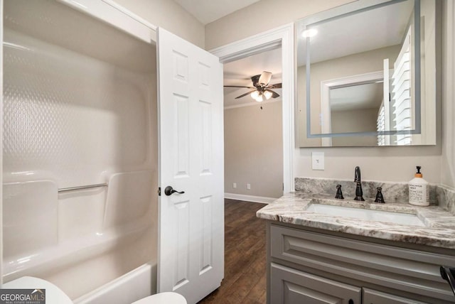 full bath with toilet, ceiling fan, vanity, wood finished floors, and baseboards