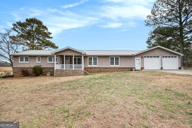 ranch-style home featuring driveway, a porch, an attached garage, and a front yard