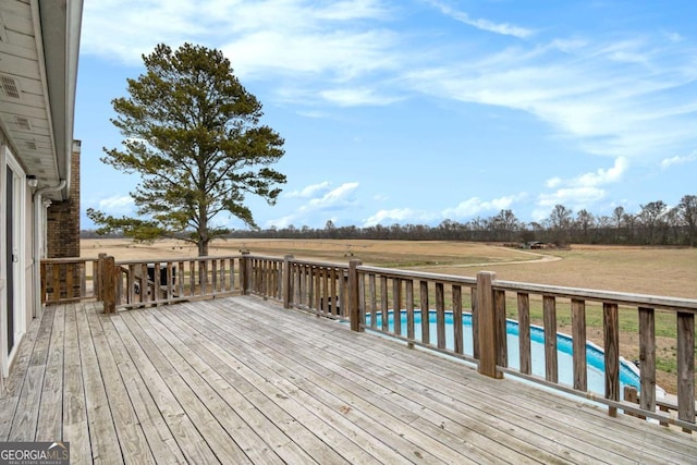 deck featuring a rural view and an outdoor pool