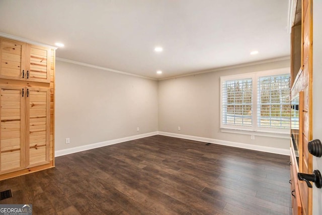 interior space featuring dark wood-style floors, crown molding, and baseboards