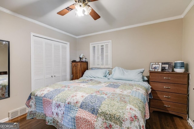 bedroom with dark wood-style flooring, a closet, visible vents, and crown molding