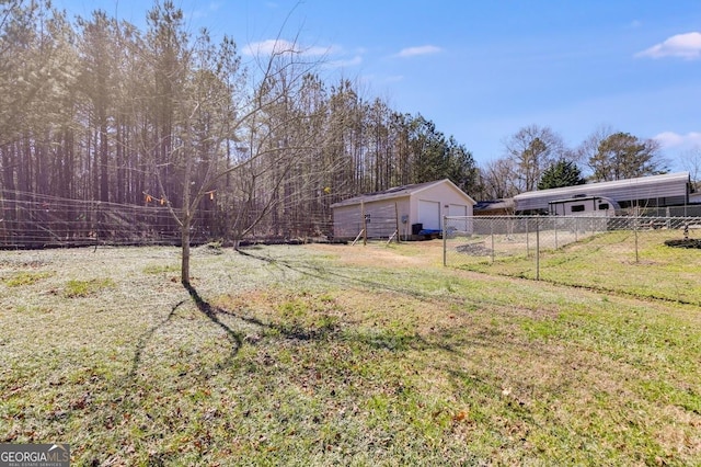 view of yard with a garage, fence, and an outdoor structure