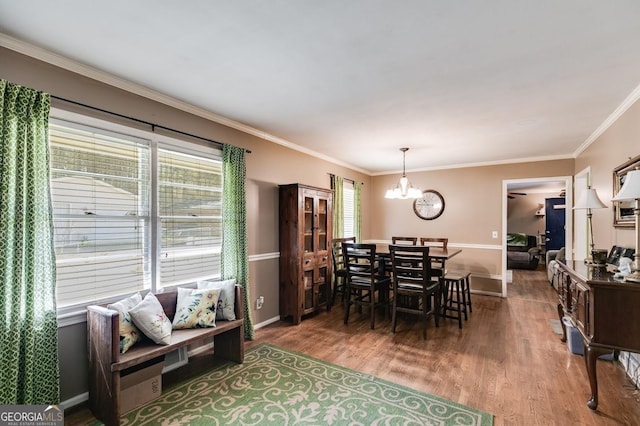 dining area with baseboards, ornamental molding, a chandelier, and dark wood-style flooring