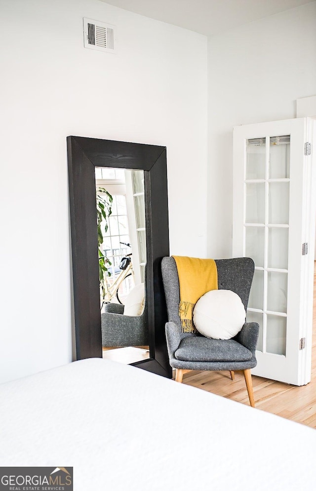 living area featuring wood finished floors and visible vents