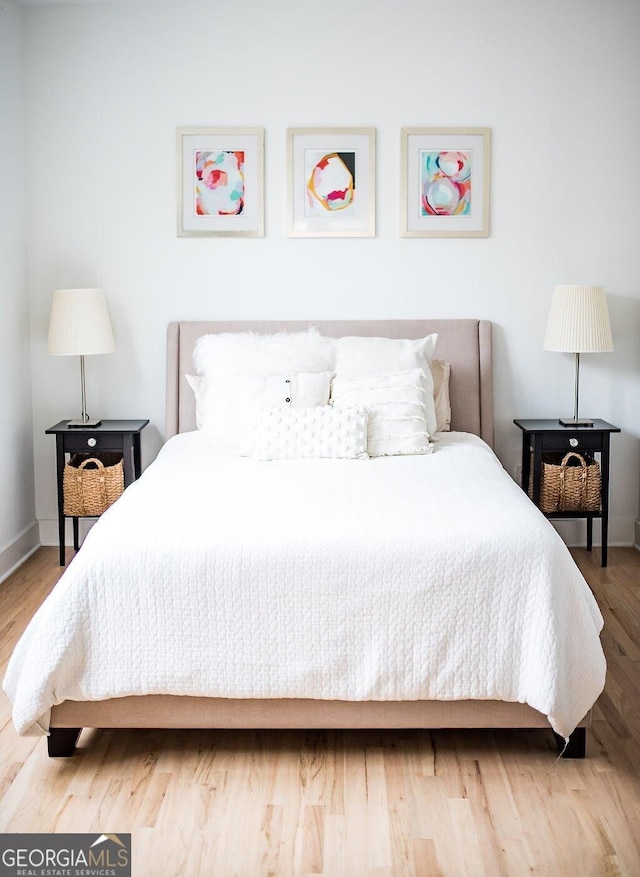 bedroom featuring baseboards and wood finished floors