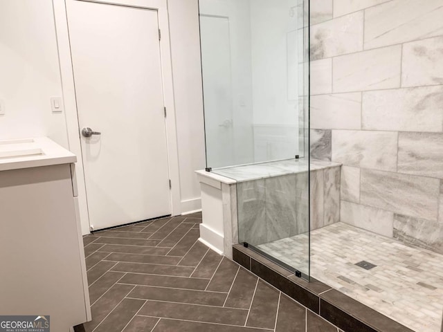 full bath with vanity, a tile shower, and tile patterned floors