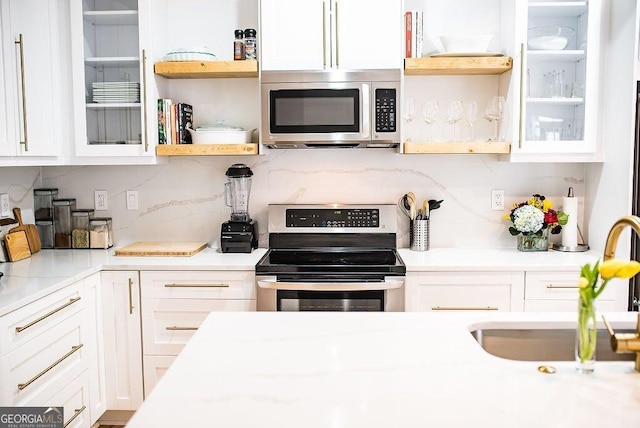 kitchen featuring white cabinets, glass insert cabinets, stainless steel appliances, open shelves, and a sink