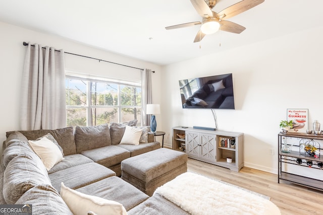 living room with light wood-style flooring, baseboards, and ceiling fan