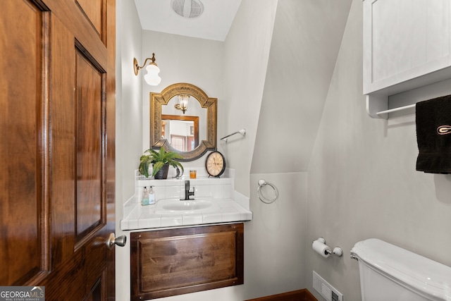 bathroom featuring visible vents, vanity, and toilet