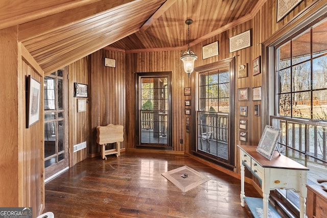 doorway to outside with wood ceiling, dark wood finished floors, and wooden walls