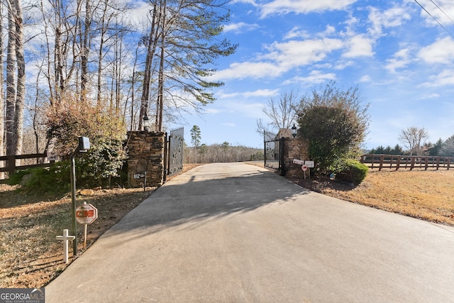 view of street featuring a gate, driveway, and a gated entry