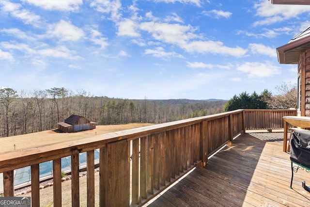 wooden terrace featuring a view of trees