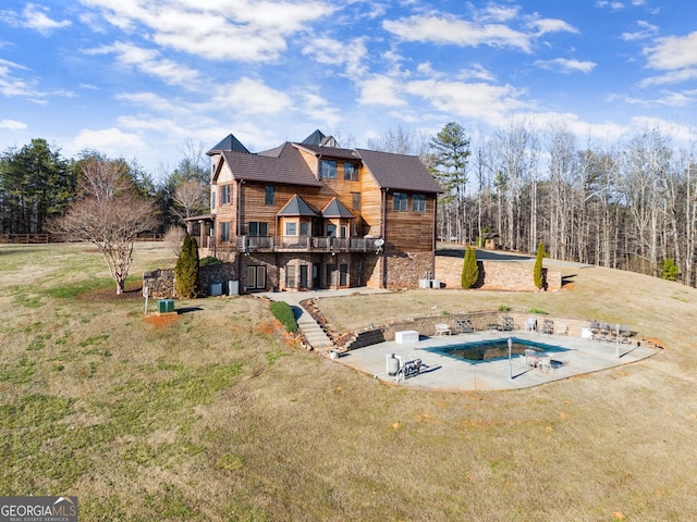 back of house with a yard, a patio area, and a covered pool