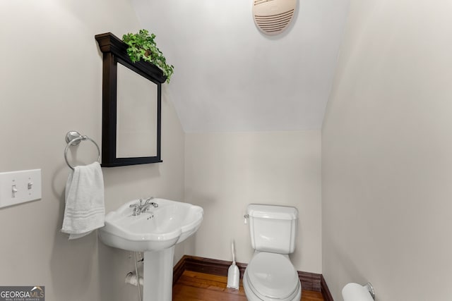 bathroom with visible vents, toilet, vaulted ceiling, wood finished floors, and baseboards